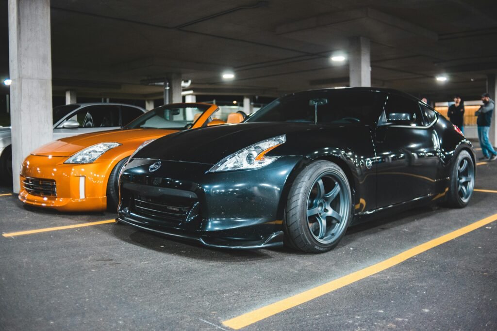 Black and orange luxury sports cars parked in a modern underground garage, exuding power and style.